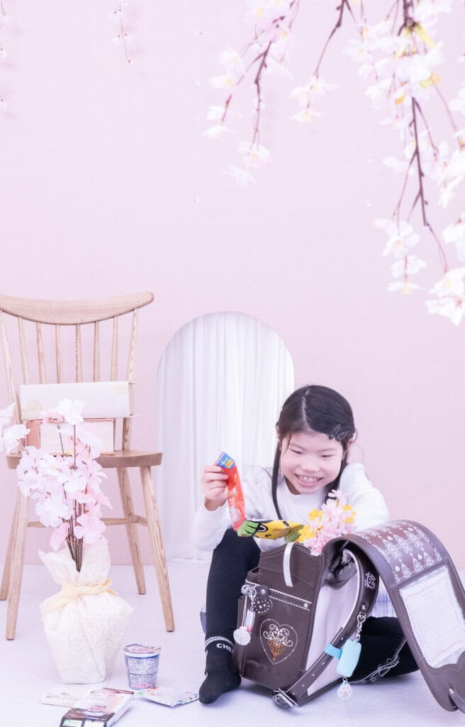 ランドセルにお菓子を詰める子供